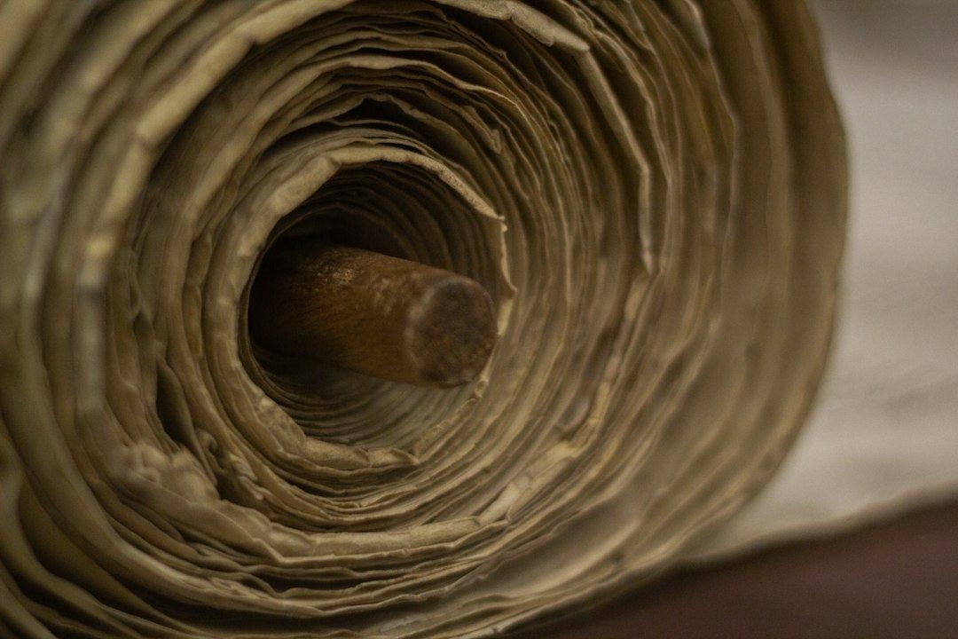 Close-up van een opgerolde, oud uitziende tekstrol met houten rolstok